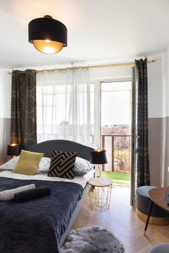 ein Schlafzimmer mit einem Bett und einem großen Fenster in der Unterkunft ClickTheFlat Conrada Apart Rooms in Warschau