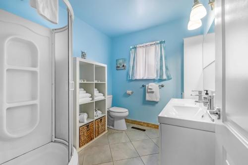 a blue bathroom with a sink and a toilet at Westside Beauty in Santa Cruz