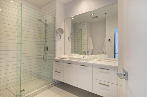 a bathroom with two sinks and a glass shower at Les Immeubles Charlevoix - Le 760608 in Quebec City