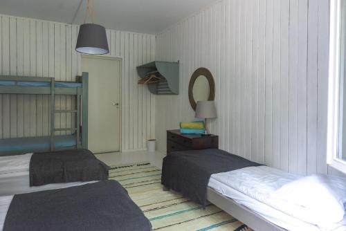 a bedroom with two beds and a mirror at Saarjärve Villa järve ääres 28-le, 8 magamistuba in Tromsi