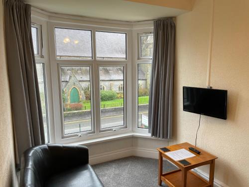 a room with a couch and a large window at Bron Menai Guest House in Caernarfon