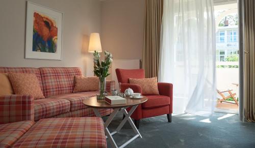 a living room with a couch and a table at ROEWERS Privathotel & Spa in Ostseebad Sellin