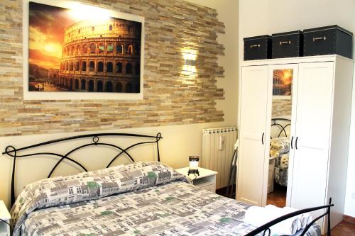 1 dormitorio con 1 cama y una foto del coliseo en 50 Passi Colosseo Apartment en Roma