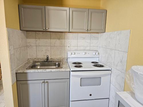 a kitchen with a white stove and a sink at Westernaire Motel in Mesa