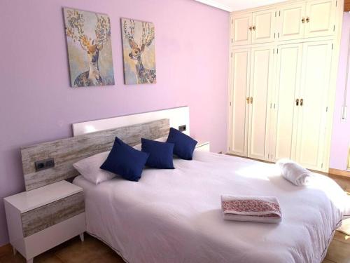 een slaapkamer met een groot wit bed met blauwe kussens bij Alojamiento Rural Harria in Yécora