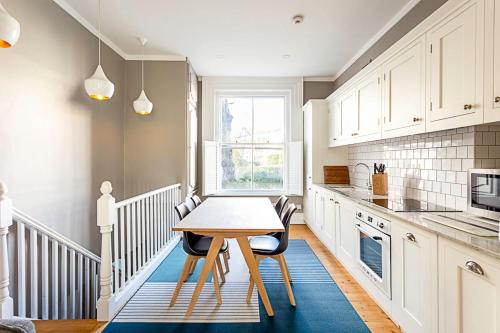 a kitchen with a table and chairs in a kitchen at Idyllic Islington Flat in London