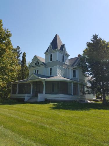 a large house with a gambrel roof on a lawn at Oaklawn Inn in Menomonie