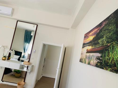 um corredor com um espelho e uma pintura na parede em Laura's Cozy HOME em Madaba