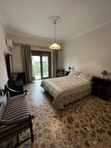 a bedroom with a bed and a large window at Family House Anavissos in Anavyssos