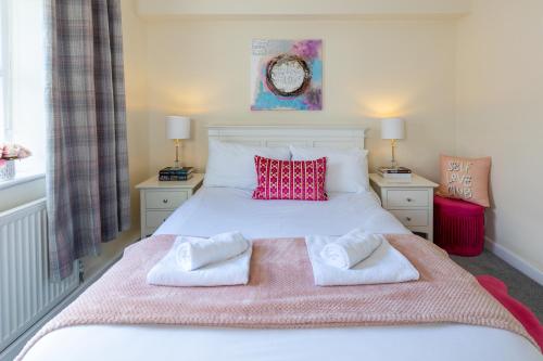 a bedroom with a white bed with two towels on it at Ilkley Place in Ilkley