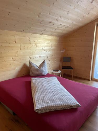 1 dormitorio con 1 cama grande en una habitación de madera en Appartements Zint, en Sankt Gallenkirch