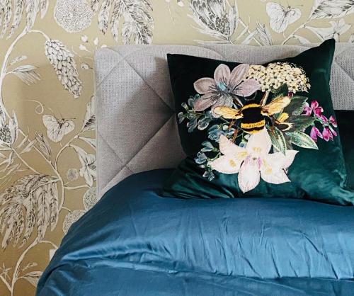 a bed with a pillow with a bee on it at Vintner Suites in Neustadt an der Weinstraße