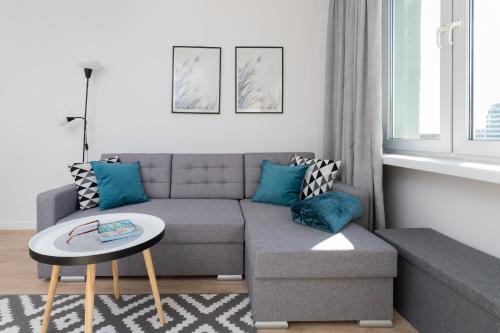 a living room with a couch and a table at Family apartment with balcony Warszawska Gdynia by Renters in Gdynia