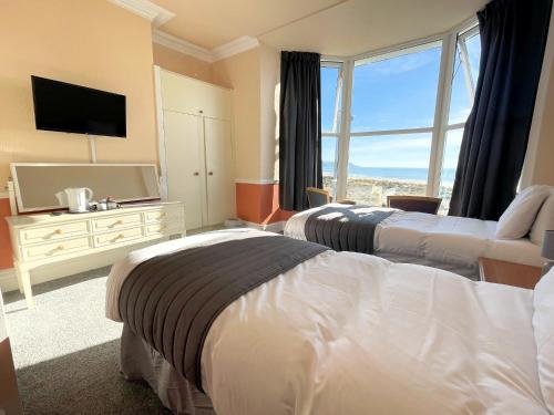 a hotel room with two beds and a television at The Sandbanks in Barmouth