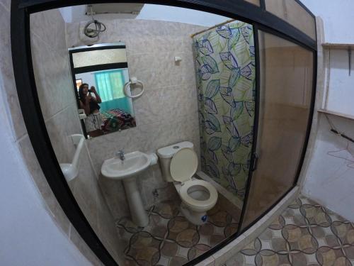 a bathroom with a toilet and a sink and a mirror at MaMMa Jungla in Ayampe