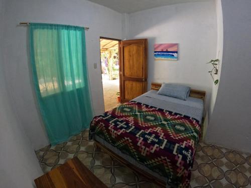 um quarto com uma cama, uma janela e uma porta em MaMMa Jungla em Ayampe