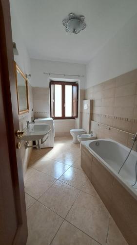 a bathroom with two sinks and a tub and two toilets at Casa TRICAGLIO in Barisciano