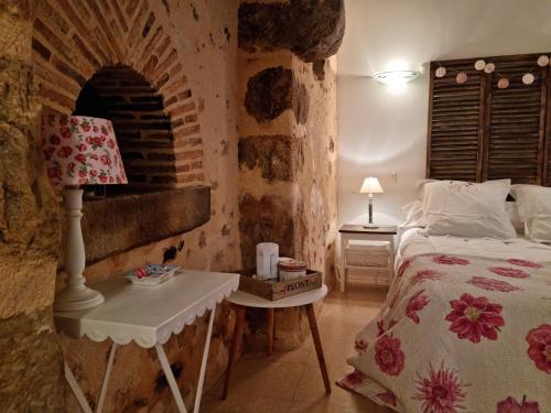 - une chambre avec un lit et un mur en briques dans l'établissement L 'Aupinouse Chambre double Pivoine avec salle d'eau privative, à La Suze-sur-Sarthe