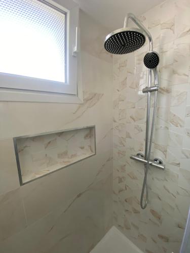 La salle de bains est pourvue d'une douche avec un pommeau de douche. dans l'établissement Un T3 chaleureux à proximité du Dôme et du métro, à Marseille