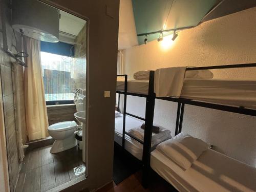 a small room with two bunk beds and a bathroom at M - Square Private Rooms in Skopje