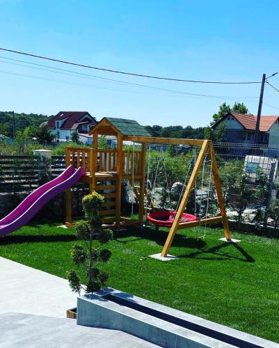 a childrens playground with a slide and a swing at Pensiunea NOVO in Baile Felix