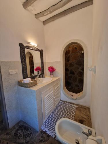 a bathroom with a sink and a mirror at Waridi House in Watamu