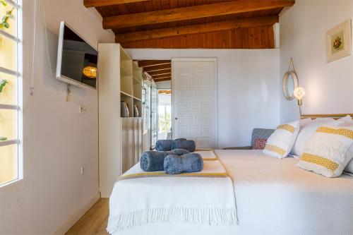 a bedroom with a white bed with two teddy bears on it at Villa la Orilla in Benajarafe