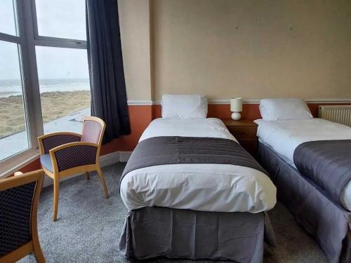 a hotel room with two beds and a large window at The Sandbanks in Barmouth