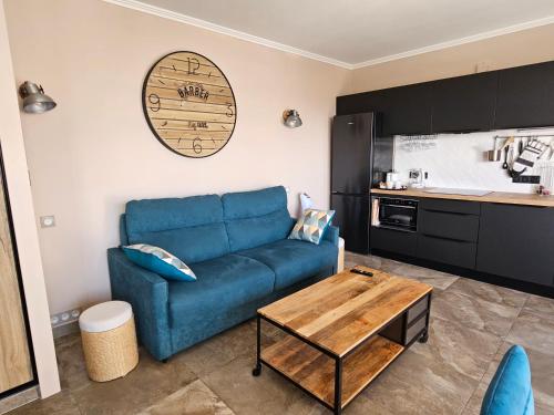 un salon avec un canapé bleu et une table dans l'établissement Cannes President vue mer, festival, quartier forville le Suquet, à Cannes