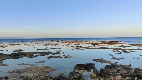 a large body of water with rocks and the ocean at Oltremare Marzamemi in Marzamemi