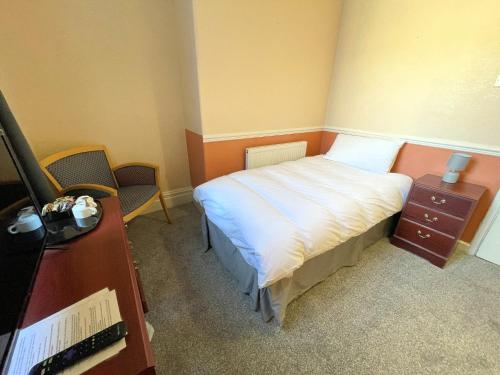 a small bedroom with a bed and a desk at The Sandbanks in Barmouth