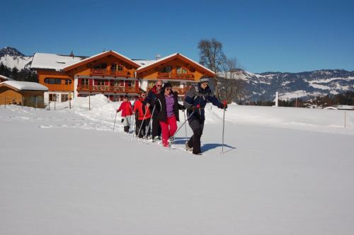 a group of people on skis in the snow in front of a lodge at Feriengut Unterhochstätt in Schwendt