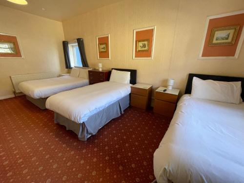 a hotel room with two beds with white sheets at The Sandbanks in Barmouth