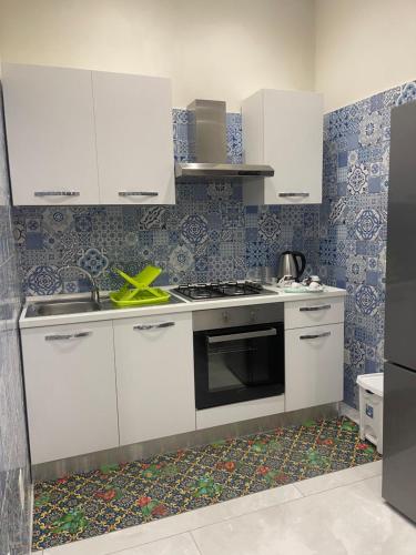 kuchnia z białymi szafkami i kuchenką w obiekcie Nase e cane home Napoli w mieście Neapol