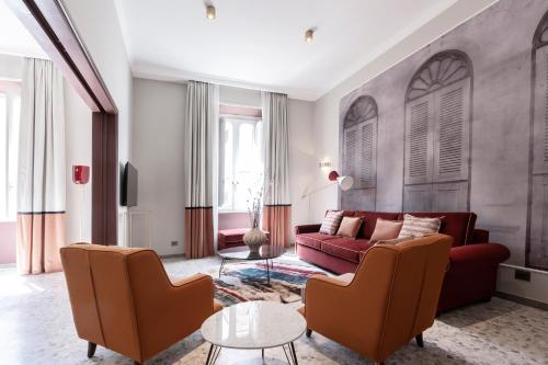 a living room with a red couch and two chairs at Be Mate Castel Sant'Angelo in Rome