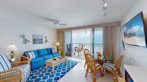 sala de estar con sofá azul y mesa en Beachfront 1 Bed w/ On Site Tiki Bar/Restaurant!, en Marco Island