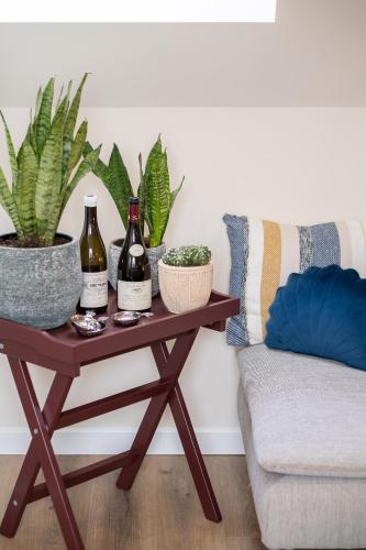 a table with wine bottles and plants on it next to a couch at Le Sommelier in Bailleul