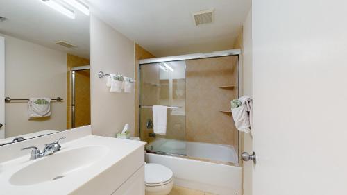 uma casa de banho com um lavatório, um WC e um chuveiro em Beachfront 1 Bed w/ On Site Tiki Bar/Restaurant! em Marco Island