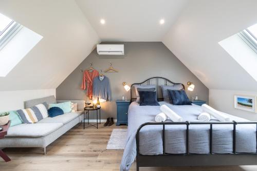 um quarto no sótão com uma cama e um sofá em Le Sommelier em Bailleul
