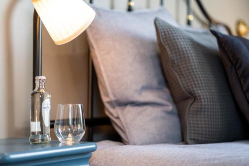 a bottle and glasses on a table with a lamp at Le Sommelier in Bailleul