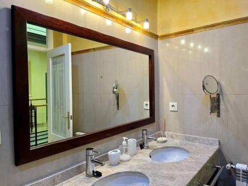 baño con 2 lavabos y espejo grande en Apartamento Suite Alameda de Hercules en Sevilla