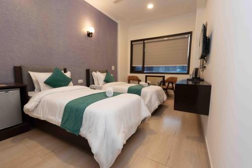 a hotel room with two beds and a television at Plaza Residency in Gurgaon