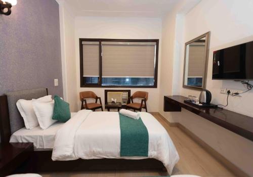a bedroom with a large bed and a window at Plaza Residency in Gurgaon