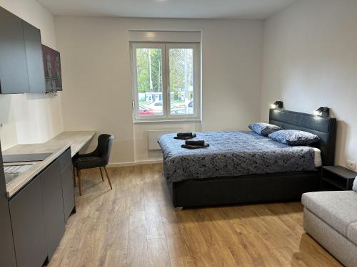 a bedroom with a bed and a desk and a kitchen at Park Maksimir Apartments in Zagreb