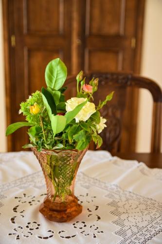 a vase filled with flowers sitting on a table at The Antique House in Batsi