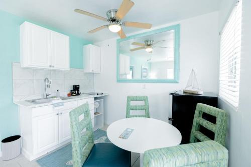 eine Küche mit einem Tisch und Stühlen sowie einem Deckenventilator in der Unterkunft Cabanas of Treasure Island in St Pete Beach