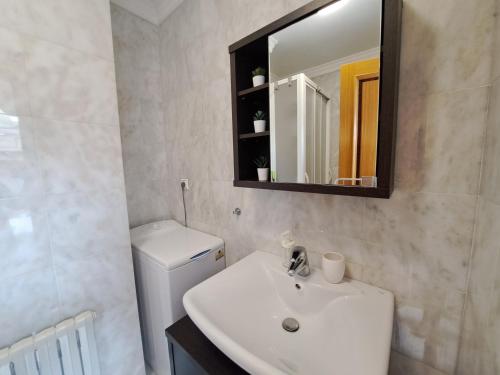 a bathroom with a sink and a toilet and a mirror at Vigo centro, ático. in Vigo