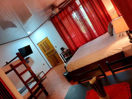 an overhead view of a bedroom with a bed and red curtains at Hotel Casa Vito Beachfront in Puerto Viejo