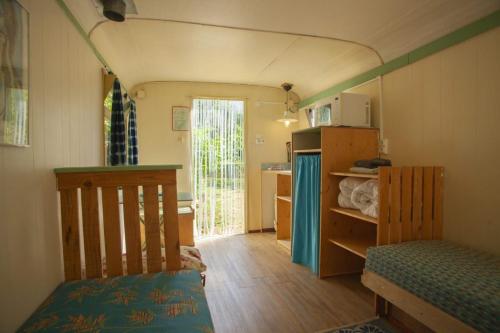 Cette petite chambre comprend un lit et une cuisine. dans l'établissement le bon chemin roulotte, à Fage