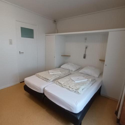 a small bedroom with two beds in it at Vakantiehuisje Martina 18 in Vlissingen